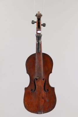un gros plan d'un violon suspendu à une corde accrochée au mur