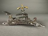 a metal object that looks like a bird with a sword on it