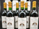 six bouteilles de vin rouge sont alignées sur une table