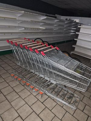 many empty shopping carts sitting in a store aisle