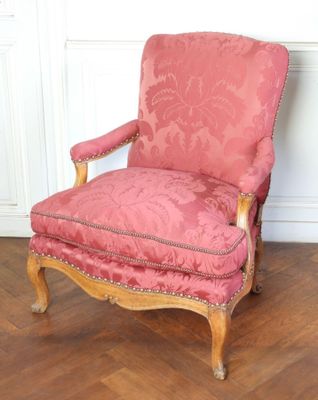 une image représentant une chaise rose posée sur un parquet en bois massif
