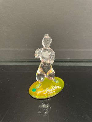 une figurine en verre représentant un homme sur une planche de surf