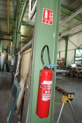 un extincteur fixé à un poteau dans un entrepôt