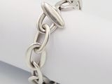 un gros plan d'un bracelet à chaîne en argent posé sur une serviette