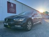 une Volkswagen Passat noire garée devant un immeuble