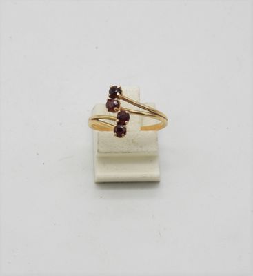 un gros plan d'une bague en or sertie de deux grenats