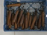 a lot of hot dogs in a basket on the floor
