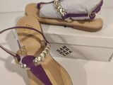 the purple sandals are next to a white box on the table