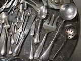 a lot of silver spoons and spoons on a tray