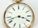 a gold pocket watch with roman numerals on the face