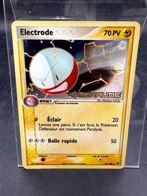 une carte Pokémon dans une boîte transparente posée sur une table