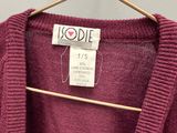 un pull violet sur un cintre dans un magasin, avec une étiquette de prix