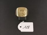 a close up of a gold ring on a black surface with a price tag