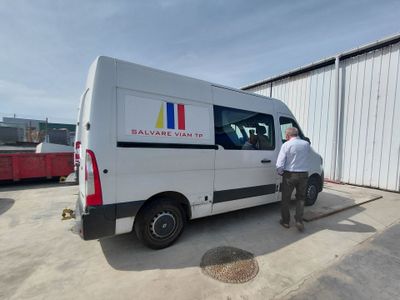 un homme qui se tient à côté d'une camionnette blanche