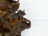 a wooden sculpture of a bird sitting on a tree branch
