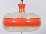 an orange and white light hanging from a rope on a white wall