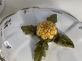 a plate with a pineapple on it and a bowl with a flower on it