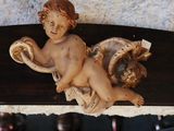 a figurine of a child on a shelf next to a vase