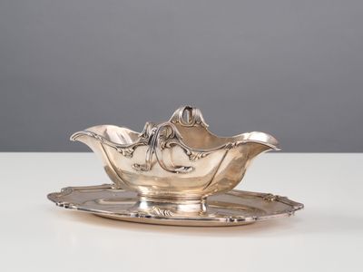 un plateau ancien en argent sur lequel sont posés un bol et une soucoupe