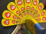 a wooden toy peacock that is sitting on a table