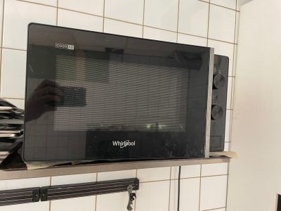 un micro-ondes posé sur une étagère dans une cuisine
