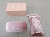a pink velvet case and a pink eyeglass case on a gray surface