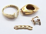 une bague en or et deux autres bagues en or posées sur une surface blanche