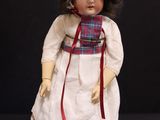 a small doll that is wearing a dress and a hat