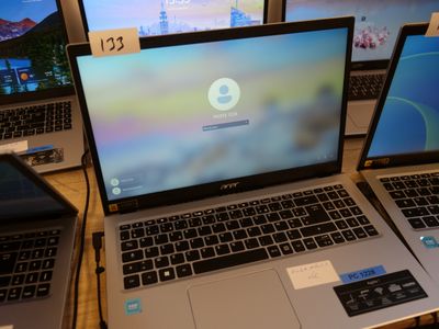 three laptops are sitting on a table in front of a computer monitor