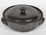 a black pot with a lid on a white surface