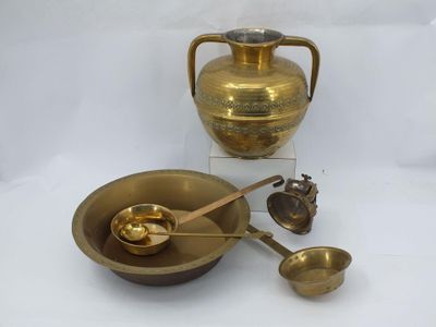 un vase en or et un bol avec des cuillères posés sur une table