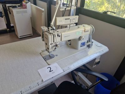 une photo d'une machine à coudre posée sur une table dans une pièce