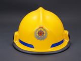 a close up of a yellow fireman ' s helmet on a black background