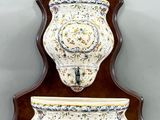 pair of wall sconces in the shape of vases on a wall