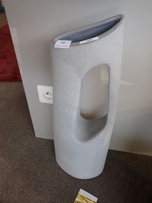 des toilettes avec un distributeur de papier posé au sol à côté d'un distributeur de papier toilette
