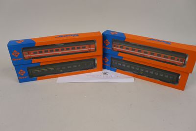 deux wagons orange et bleu placés l'un à côté de l'autre sur une surface blanche