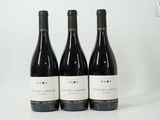 three bottles of wine sitting on top of a white table