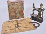 an old sewing machine next to a box with a picture on it