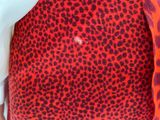 the back of a woman wearing a red and black leopard print skirt