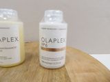 two bottles of olaplex on a wooden table