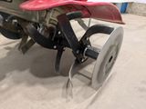 a tractor with a plow attached to it in a garage