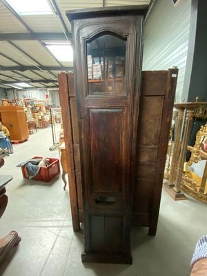 a tall wooden cabinet in the middle of a room