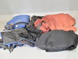 un tas de vêtements par terre, à côté d'un sac à dos