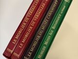 trois livres sont empilés sur une table