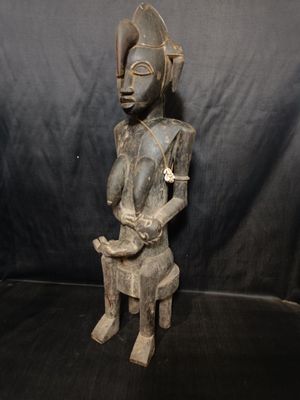 Statuette de femme en bois allaitant son enfant, décorée de cauris