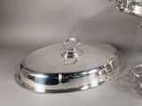 a silver plate with a silver lid on a table