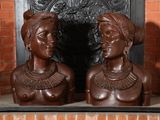 deux statues représentant une femme et un homme devant une cheminée