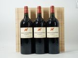 trois bouteilles de vin dans un coffret en bois sur une surface blanche
