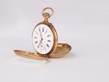 a gold pocket watch sitting on a white surface