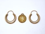 a pair of gold hoop earrings with an image of jesus